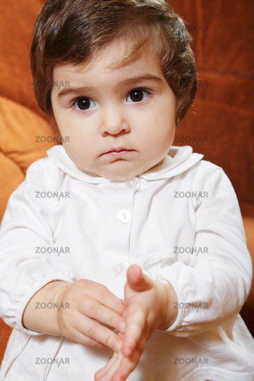 Little cute brunette baby girl in white shirt closeup photo