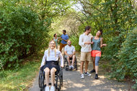 Inclusive outdoor adventure: Friends enjoying a sunny day in the park, with individuals using wheelchairs