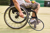 Person in wheelchair demonstrating resilience while playing tennis