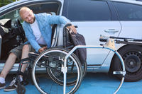 Man with a disability transfers from car to wheelchair, showcasing independence and accessibility
