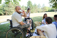Joyful gathering in the park with friends including person in wheelchair