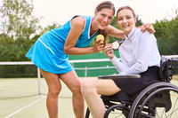 Celebration of triumph: Two athletes, one in a wheelchair, showcasing a gold medal on a tennis court